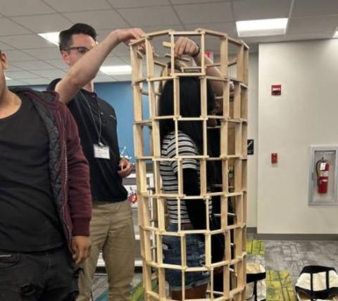 Teens building a tower with Keva Planks