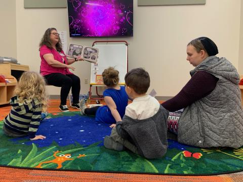 Miss Trish reading a story to a group of children