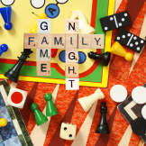 Photo of board games with scrabble pieces spelling Family Game Night
