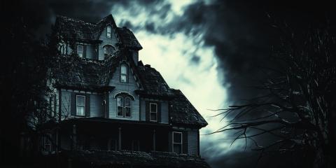 image of dark-looking house with eerie lighting behind it