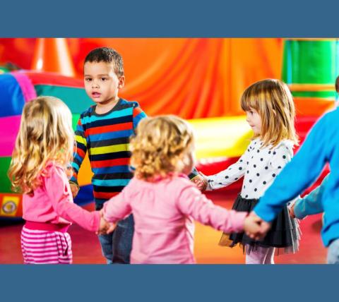 4 young children holding hands in a circle with a colorful background