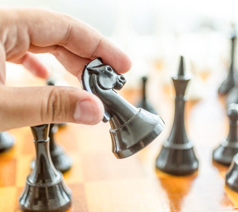 close up of hand placing a chess piece on the game board