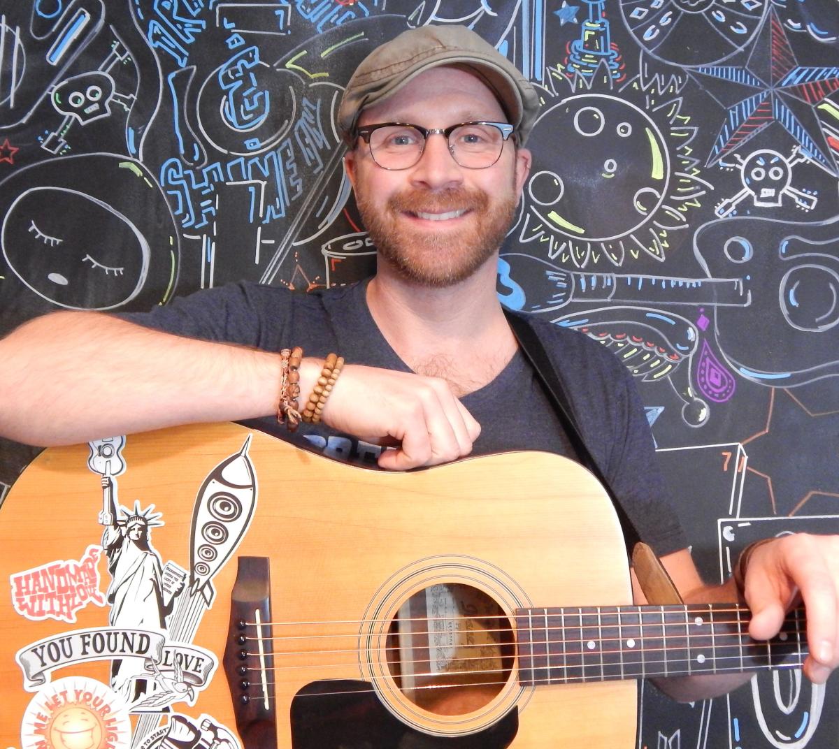 photograph of musician mark derose holding a guitar