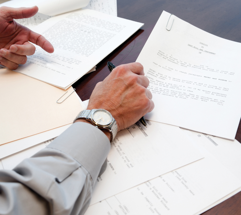 Arms over documents on a desk.