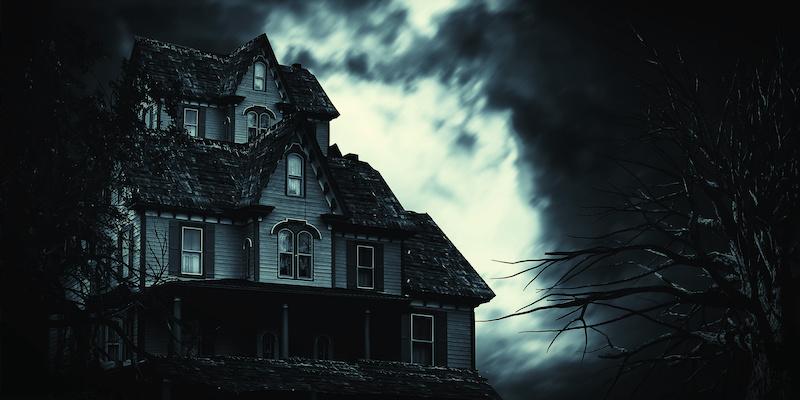 image of dark-looking house with eerie lighting behind it
